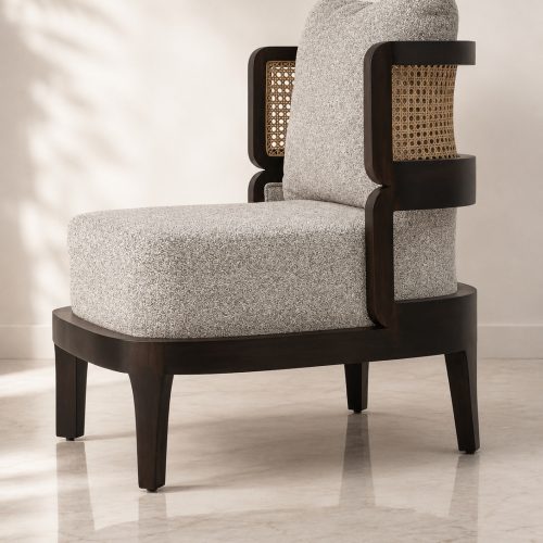 Veena accent chair angled view with boucle cushions and cane back panel