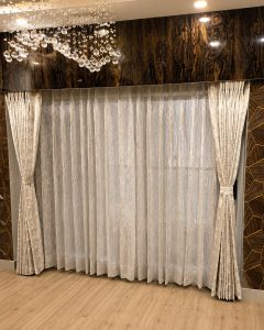 Cream sheer curtains layered with gold pelmet in a Kolkata bedroom