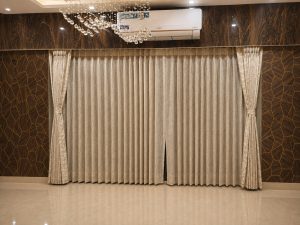 Window Coverings Kolkata: Blinds & Curtains Champagne pleated sheer curtains tied back in a wood-panelled Kolkata living room
