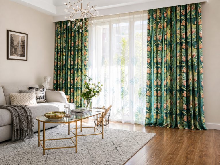 Green floral print curtains framing a balcony door in an Avikar-furnished living room